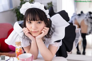 A woman dressed in a maid outfit posing for a picture.