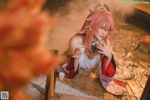 A woman in a kimono sitting in a hot tub.