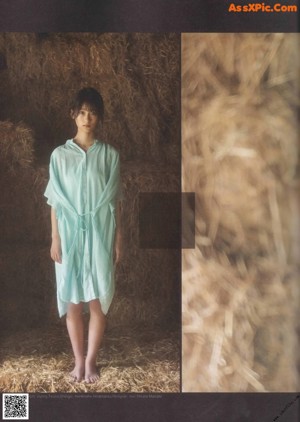 A woman in a blue dress standing in a field.