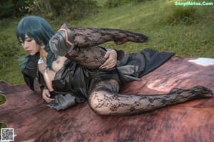 A woman laying on top of a cowhide rug in the grass.