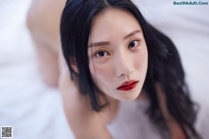 A woman with long black hair and red lipstick.