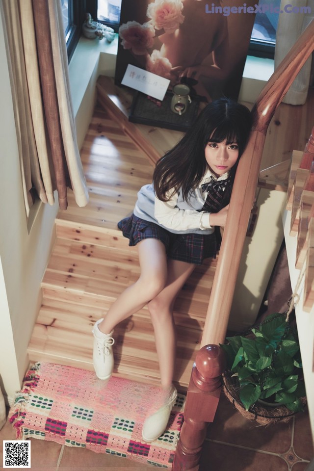 A young woman sitting on the stairs of a house.