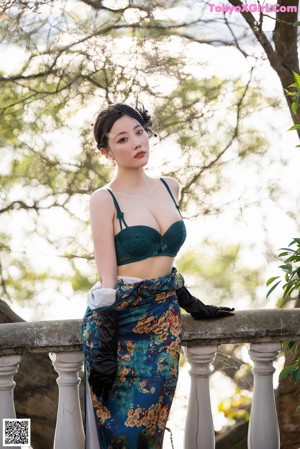 A woman in a green lingerie sitting on some steps.