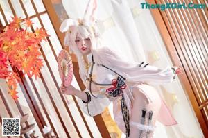 A woman in a bunny costume sitting on a swing.