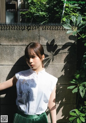 A young girl in a yellow dress sitting on the ground.