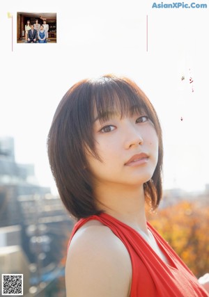 A woman in a red dress posing for a magazine cover.