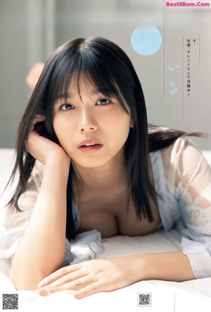 A woman in a white lingerie laying on a bed.