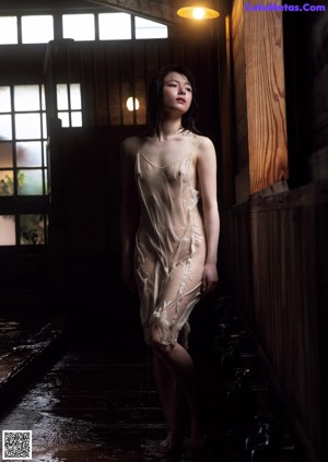 A naked woman laying on a wooden floor.