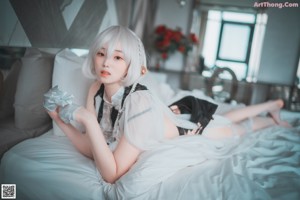 A woman laying on top of a bed in lingerie.