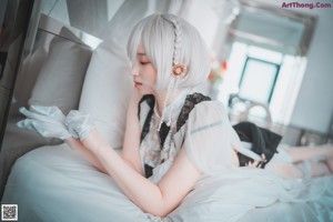 A woman laying on top of a bed next to a bouquet of flowers.