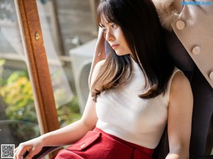 A woman sitting on a couch with her legs crossed.
