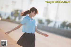 A woman in a school uniform is walking down the street.