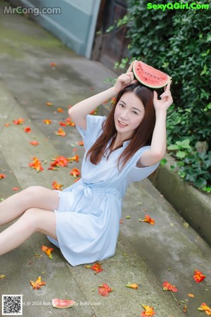 A young woman eating a slice of watermelon.