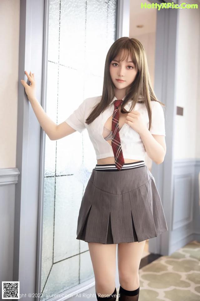 A woman in a school uniform posing for a picture.