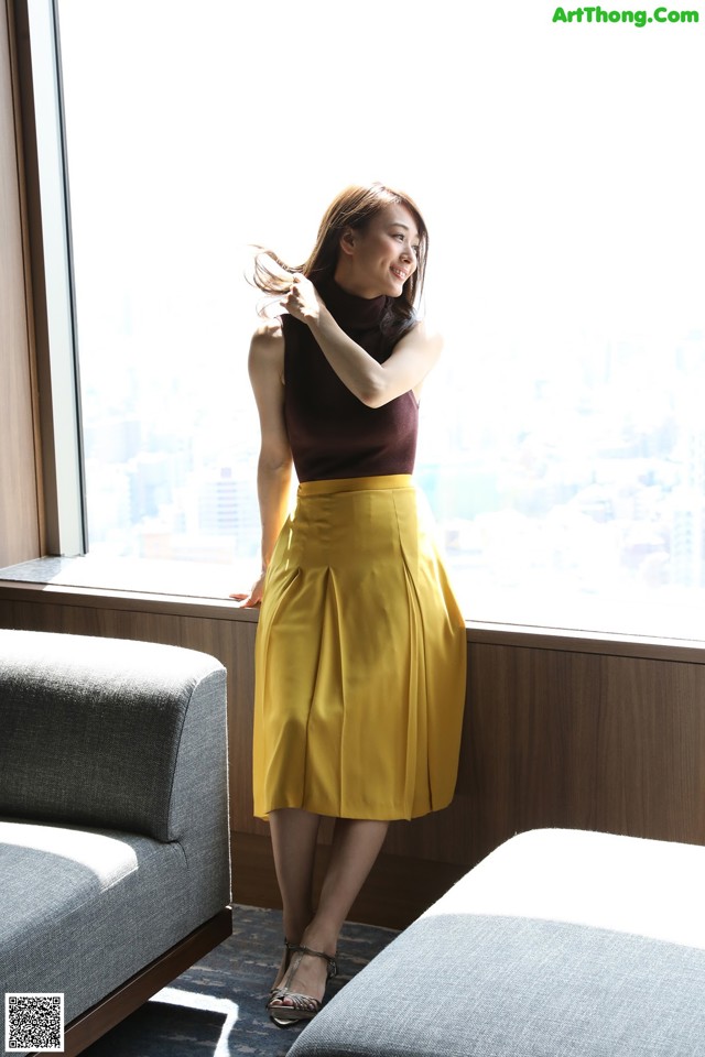 A woman standing in front of a window in a room.