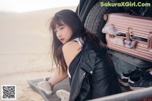 A woman sitting on top of a motorcycle in a field.