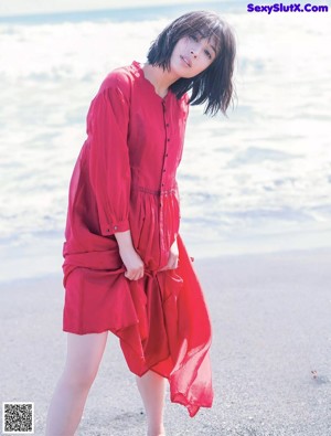 A woman in a gray dress posing for a picture.