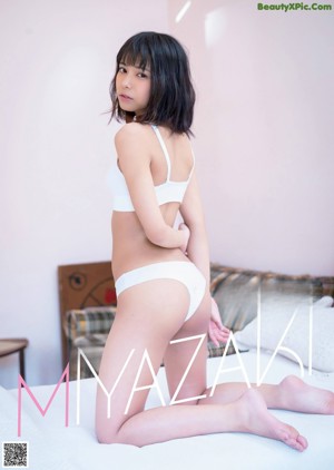 A woman in a pink bikini sitting on a window sill.