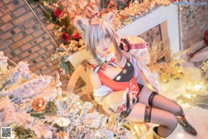 A woman sitting on the floor in front of a Christmas tree.