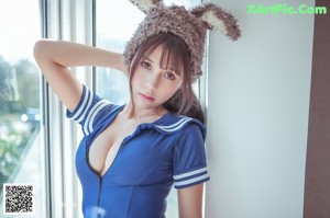 A woman in a blue dress and a furry hat.
