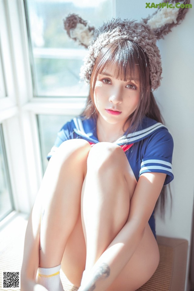 A woman in a bunny costume sitting on a window sill.
