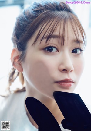 A woman with long brown hair wearing a white dress.