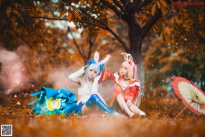 A couple of women sitting next to each other in the woods.